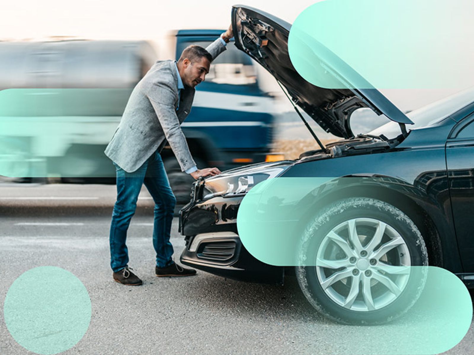 A person in business clothes looking in the bonnet of their black car.