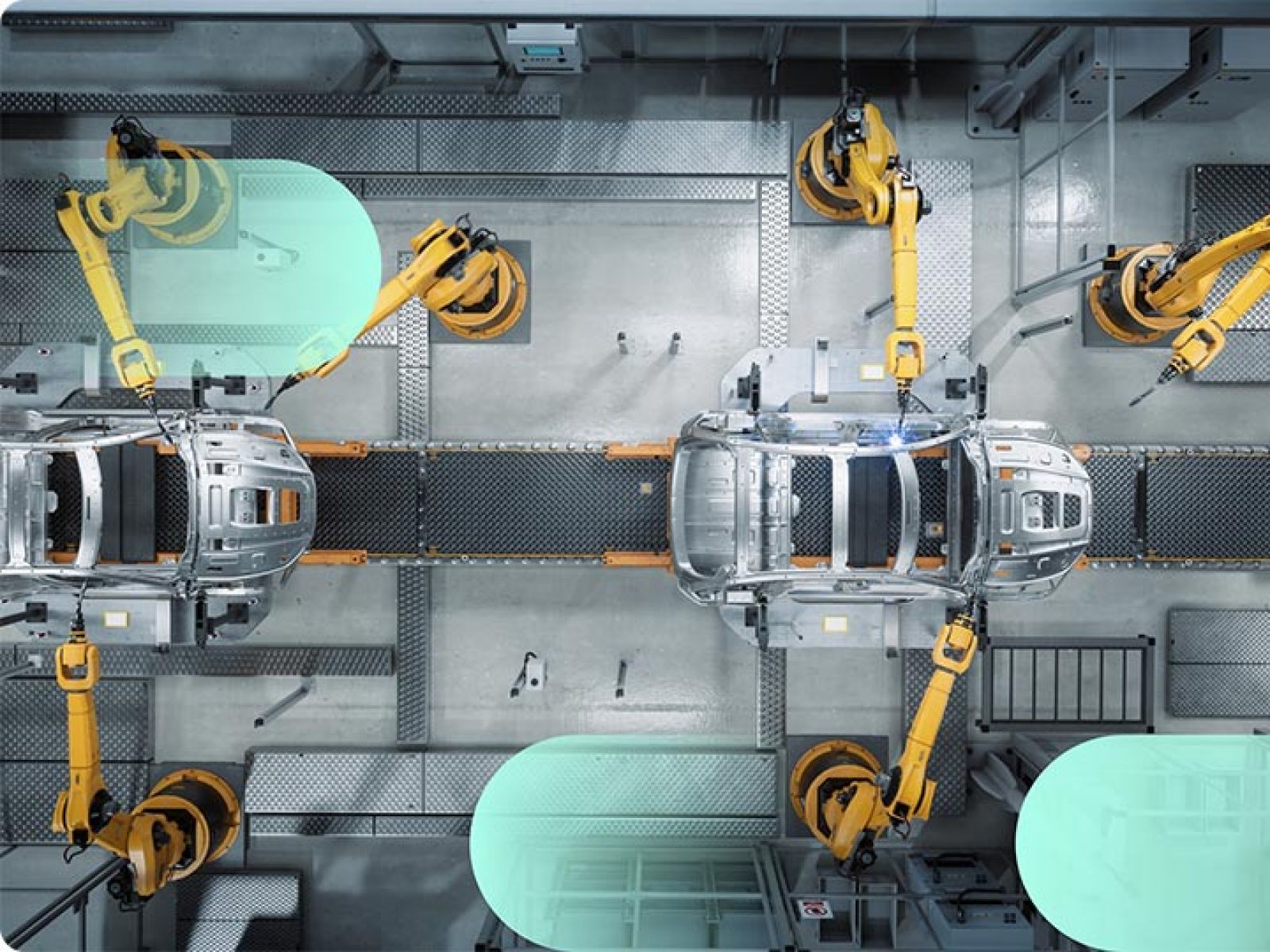 Cars being built in a factory line, with orange machines welding the car shells.